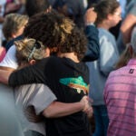 Community members embrace during a prayer vigil at First Baptist Church in Dadeville, Ala.