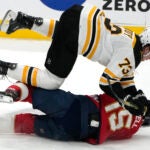 Boston Bruins defenseman Charlie McAvoy (73) lands on Florida Panthers center Anton Lundell (15) during the third period of Game 3 of an NHL hockey Stanley Cup first-round playoff series, Friday, April 21, 2023, in Sunrise, Fla.