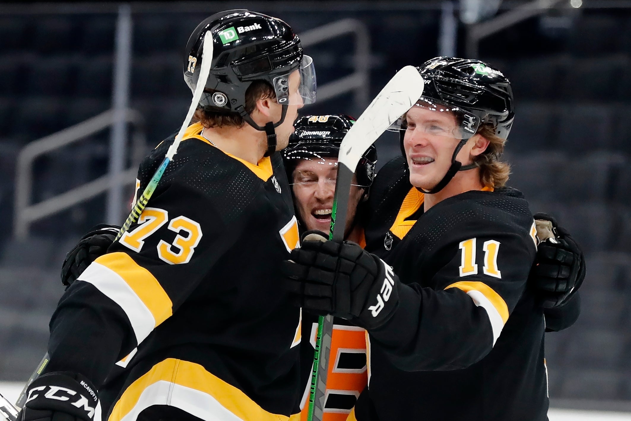 Boston Bruins' Trent Frederic (11) celebrates his goal with Charlie McAvoy (73) and Matt Grzelcyk (48) during the second period of an NHL hockey game, Friday, March 5, 2021, in Boston.