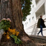 Cash App founder killed -- A woman walks past flowers left outside an apartment building where a technology executive was fatally stabbed in San Francisco.
