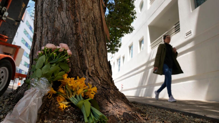 Cash App founder killed -- A woman walks past flowers left outside an apartment building where a technology executive was fatally stabbed in San Francisco.