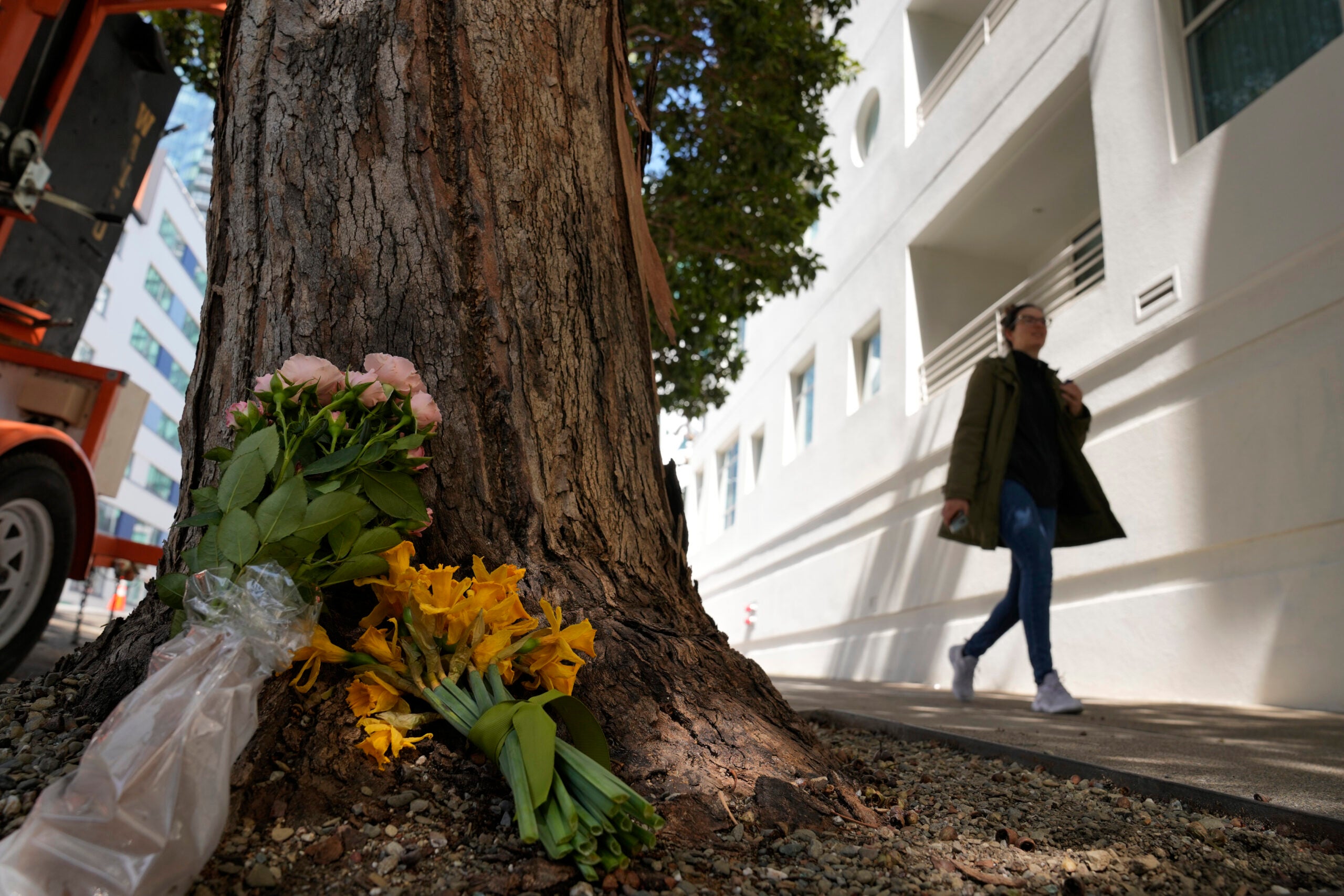 Cash App founder killed -- A woman walks past flowers left outside an apartment building where a technology executive was fatally stabbed in San Francisco.