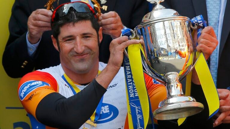 Ernst Van Dyk of South Africa holds the trophy after winning the men's wheelchair division at the 118th running of the Boston Marathon in Boston, Massachusetts April 21, 2014.