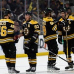 Boston Bruins' Brad Marchand (63) talks with David Krejci as Patrice Bergeron, right, talks with David Pastrnak during the third period of an NHL hockey game against the Los Angeles Kings Thursday, Dec. 15, 2022, in Boston.
