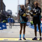 Evans Chebet of Kenya, right, and Peres Jepchirchir of Kenya pose with the trophy after winning the 126th Boston Marathon in 2022.