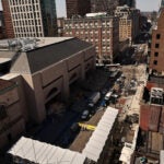 Seen from the bell tower of Old South Church, the Boylston Street finish line preparations continue. The Boston Public Library is at left. Workers prepare fresh finish line graphics on Boylston Street in advance of the Boston Marathon. It’s been years since the line has had an annual coat of new paint, with a pre-printed decal instead applied to the pavement where the runners will break the tape.