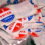 A bin of "I Voted Today" stickers rests on a table at a polling place in Stratham, N.H.