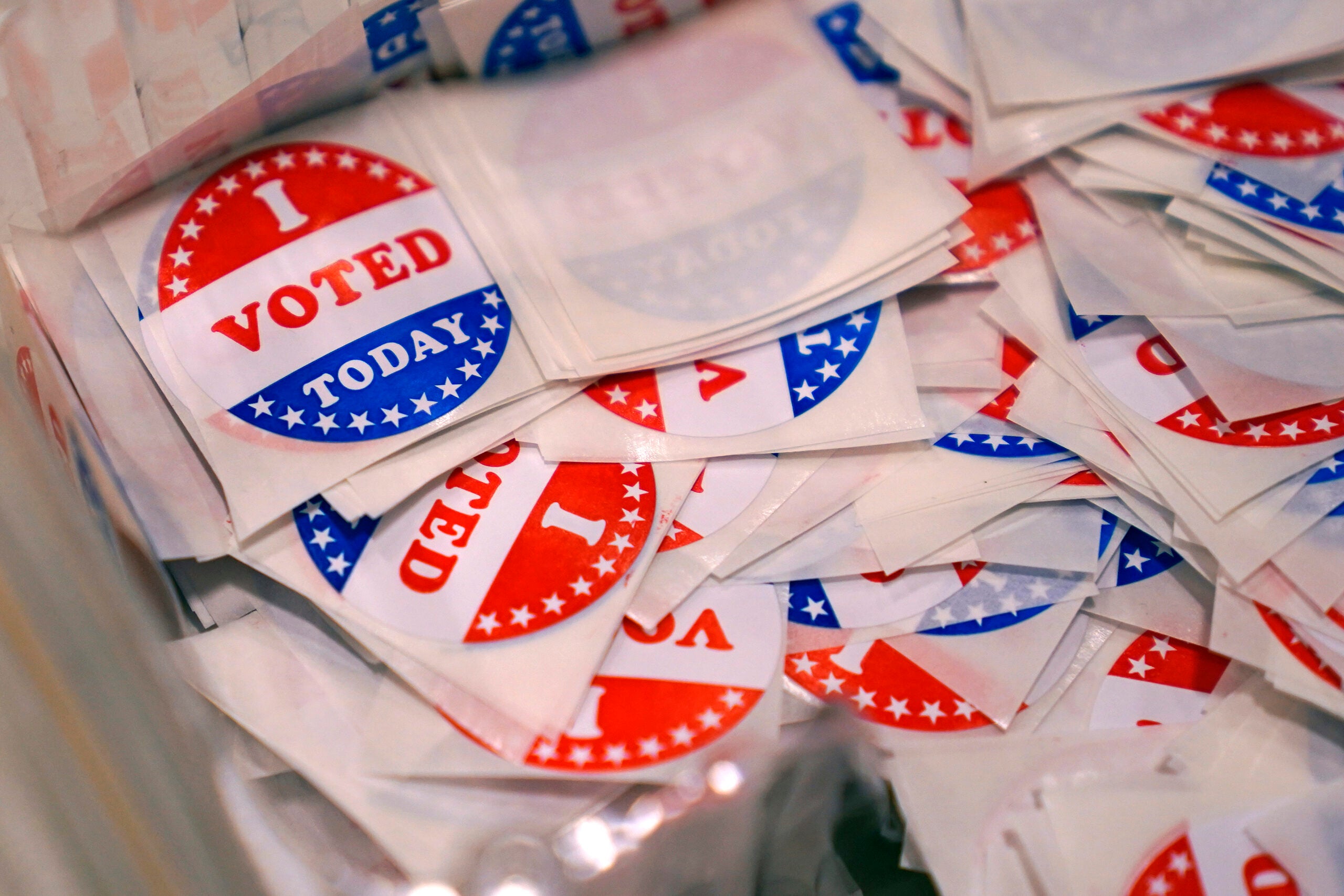 A bin of "I Voted Today" stickers rests on a table at a polling place in Stratham, N.H.