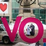 Pastor Larry Weeks prays with Amy Anderson after applying ashes to her forehead in Monument Square in Portland, Maine on Feb. 14, 2018.