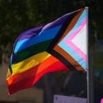A pride flag flutters in the wind