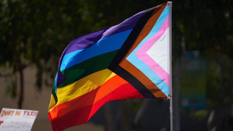 A pride flag flutters in the wind