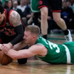 Celtics forward Sam Hauser and Raptors guard Fred VanVleet go to the court for the ball.
