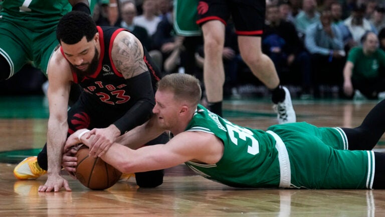 Celtics forward Sam Hauser and Raptors guard Fred VanVleet go to the court for the ball.