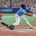 Randy Arozarena stretches across the plate to hit a shin-high ball for a single.