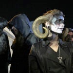 In this Oct. 29, 2015, photo, a Satanic Temple of Seattle member who gave her name as Dice wears horns as members gathered outside a football game in Bremerton, Washington.