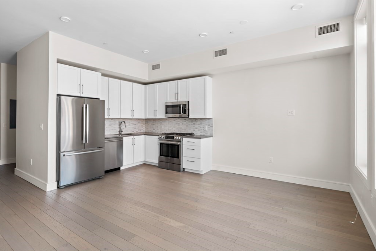 A kitchen with stainless steel appliances and white Shaker-style cabinets.
