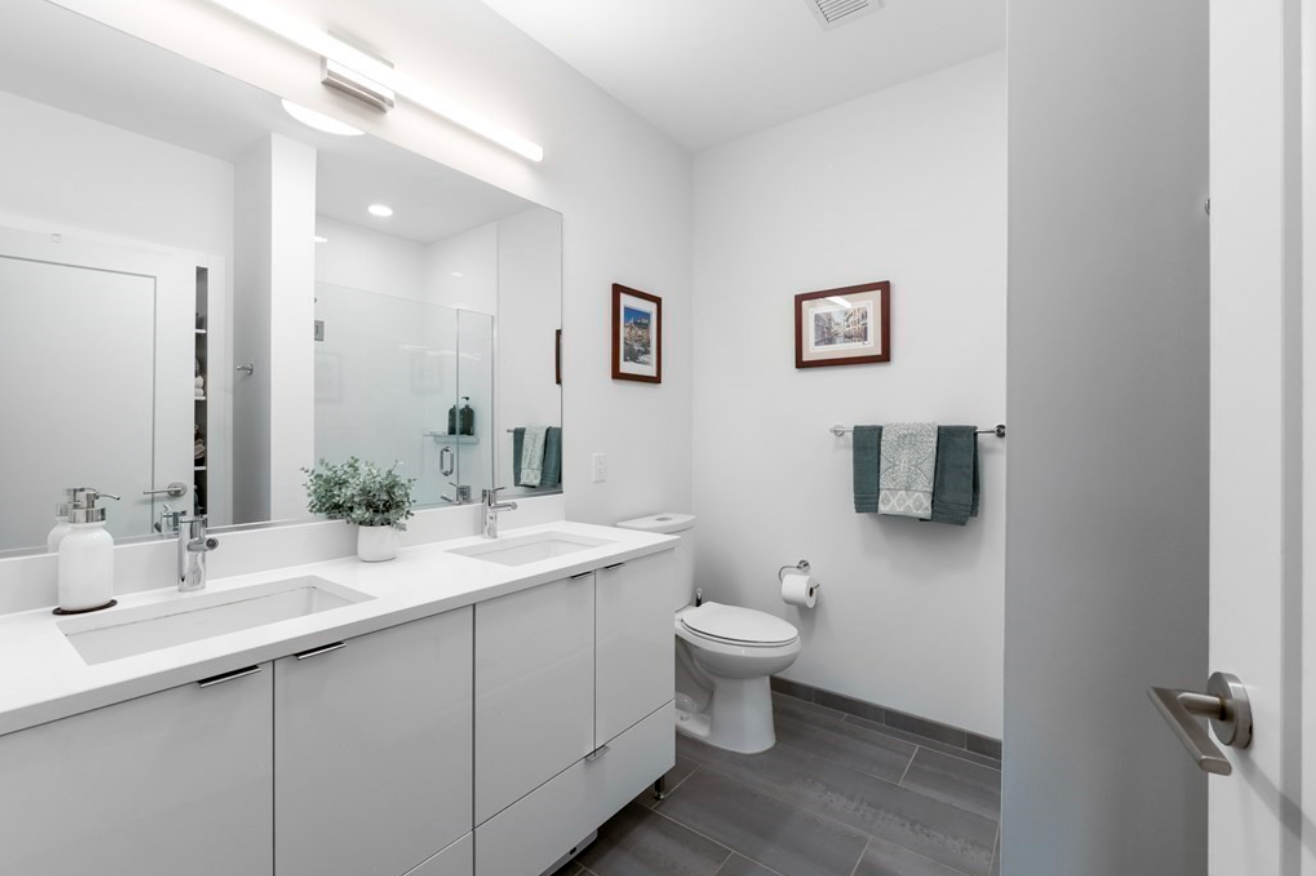 Bathroom with double vanity and light gray flat-panel cabinetry.