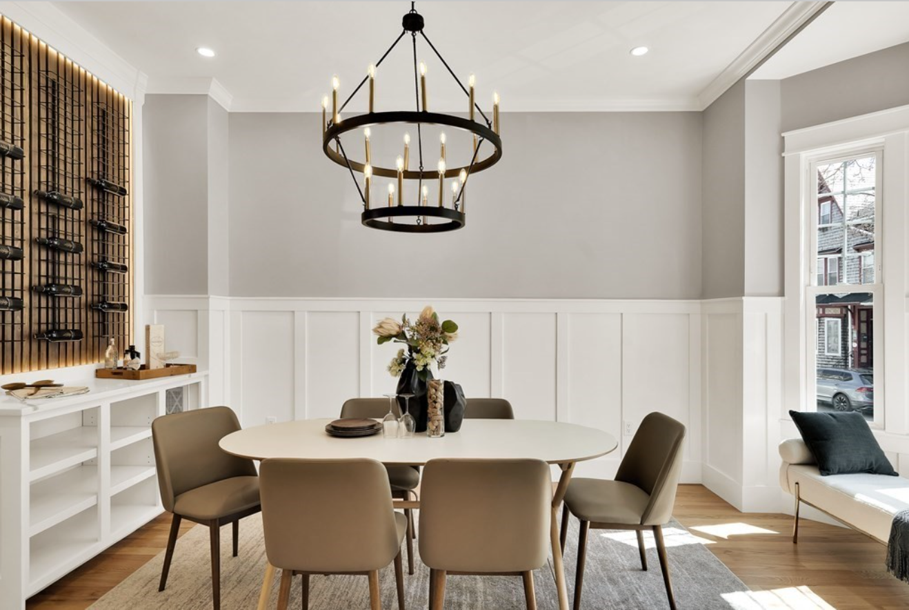 Dining area with batten-and-rail walls, a rustic chandelier, and an illuminated wine rack.
