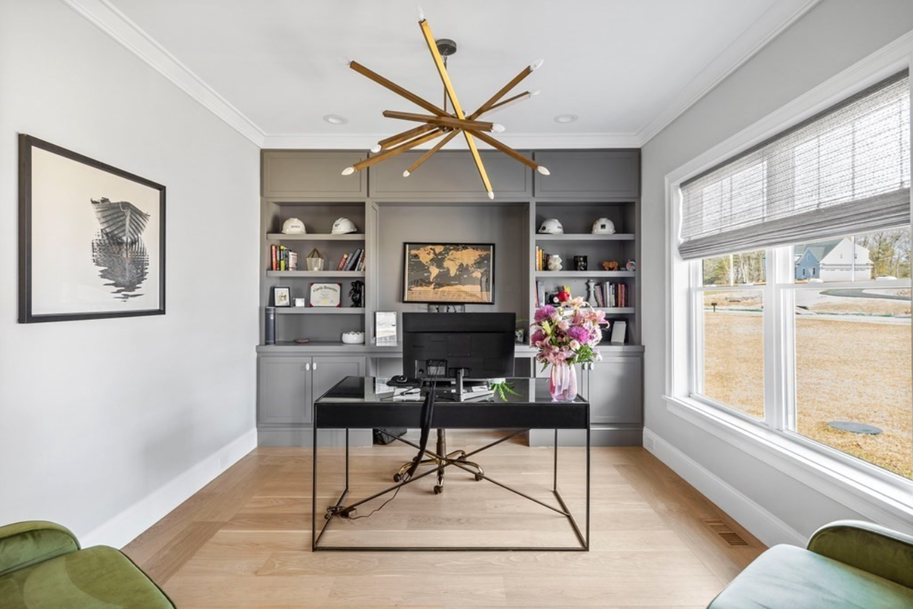 Office with built-in gray shelving and a sputnik chandelier.