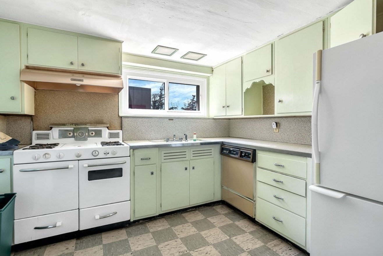 Kitchen with seafoam green cabinetry and checkered floor tiles.