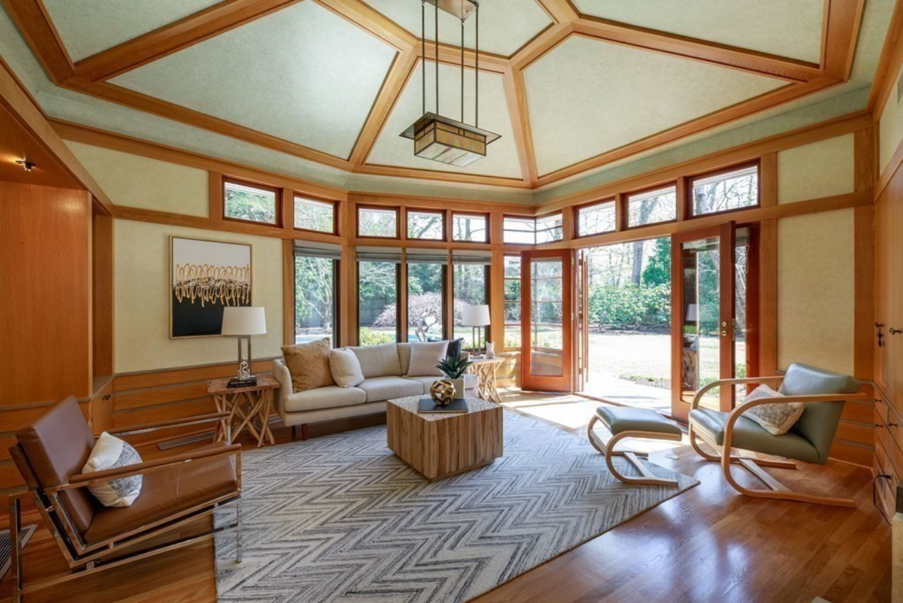 Living room with vaulted ceilings, hardwood floors, and a geometric chandelier.
