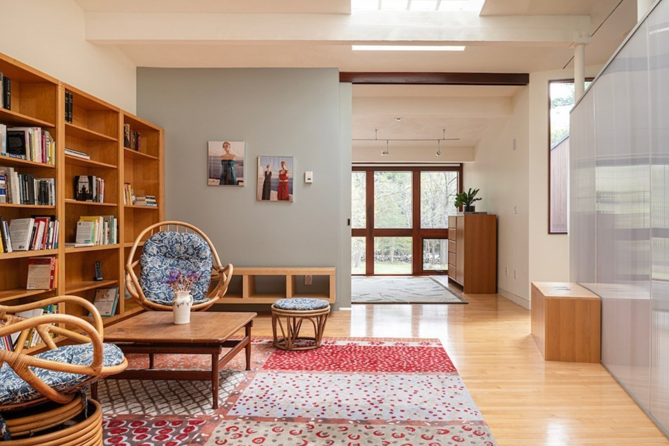 Study with light blue accent wall, hardwood floors, and built in bookshelves.