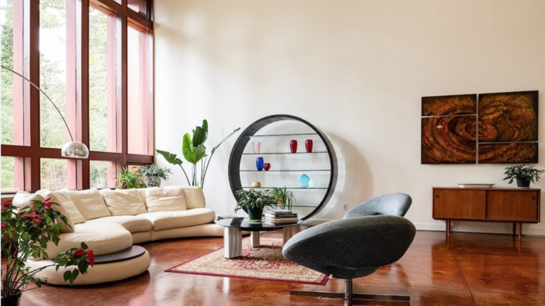 Living room with floor-to-ceiling windows, cream walls, and hardwood floors.