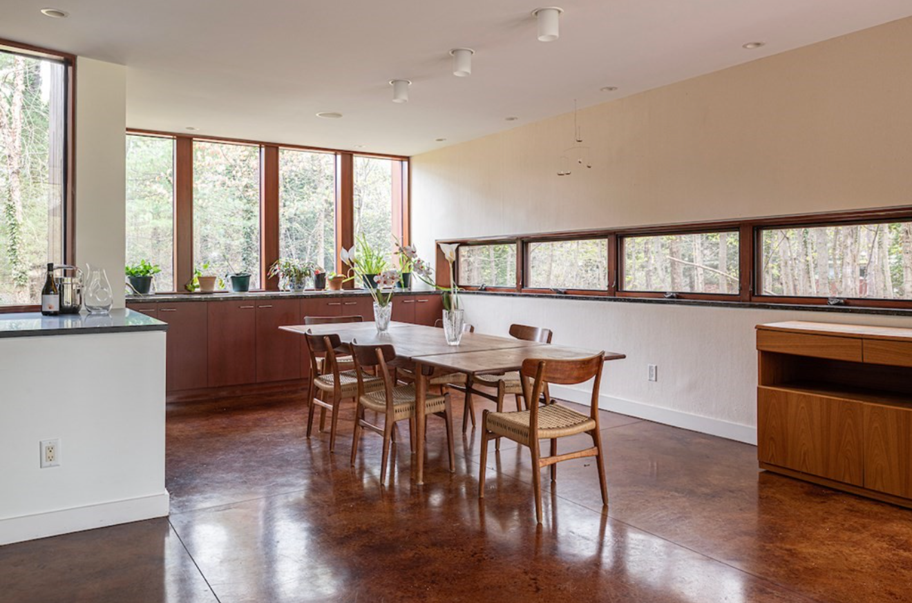 Dining room with muntinless windows and built-in wooden cabinetry.
