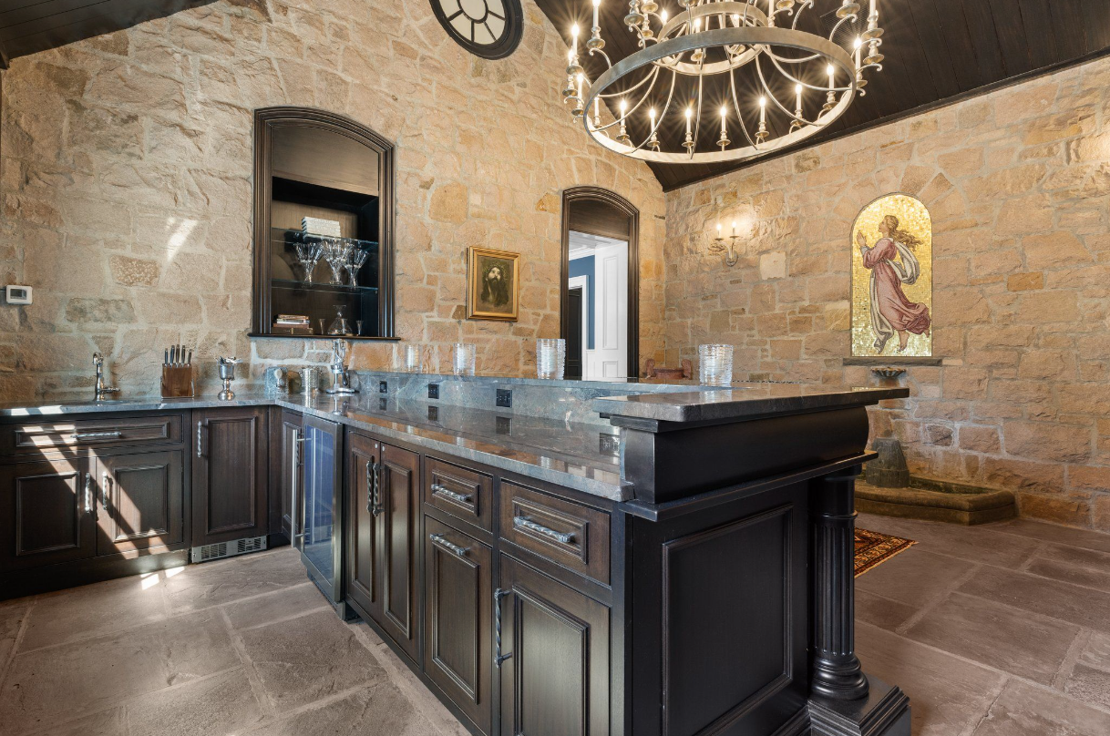 Wet bar with candle chandelier, arched doorways, and vaulted ceilings.