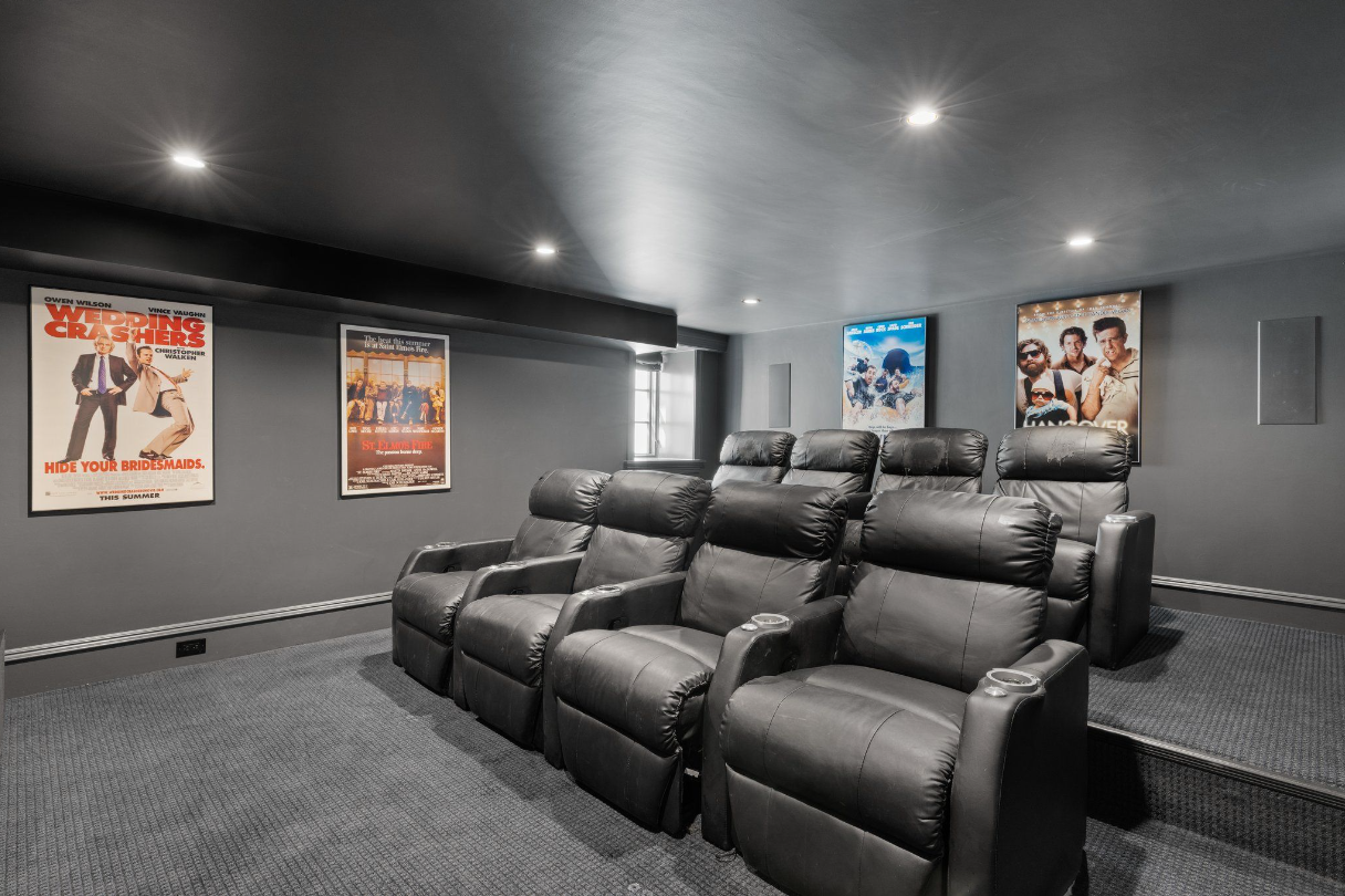 In-home theater with eight reclinable leather chairs.