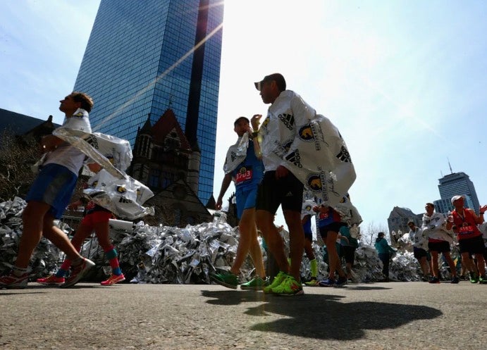 Runners walk with blankets after completing the 120th Boston Marathon in 2016.
