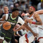 Minnesota Timberwolves guard Anthony Edwards, left, drives against Denver Nuggets forward Bruce Brown and center Nikola Jokic, right, during the second half of Game 5 of an NBA basketball first-round playoff series Tuesday, April 25, 2023, in Denver.