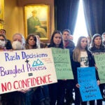Students from some Vermont State Colleges, along with others, display signs Tuesday, Feb. 21, 2023, at the Statehouse in Montpelier, Vt.