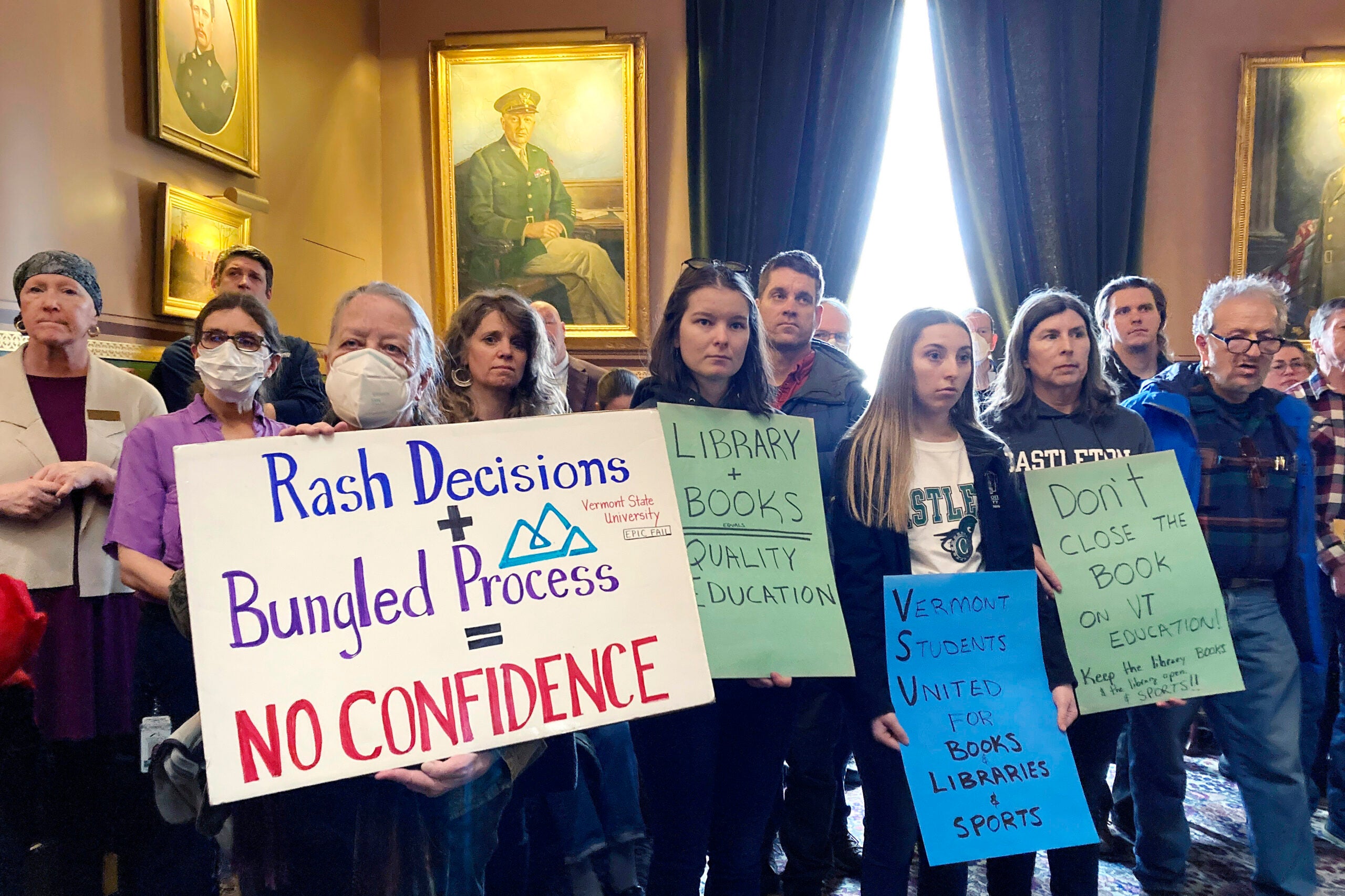Students from some Vermont State Colleges, along with others, display signs Tuesday, Feb. 21, 2023, at the Statehouse in Montpelier, Vt.