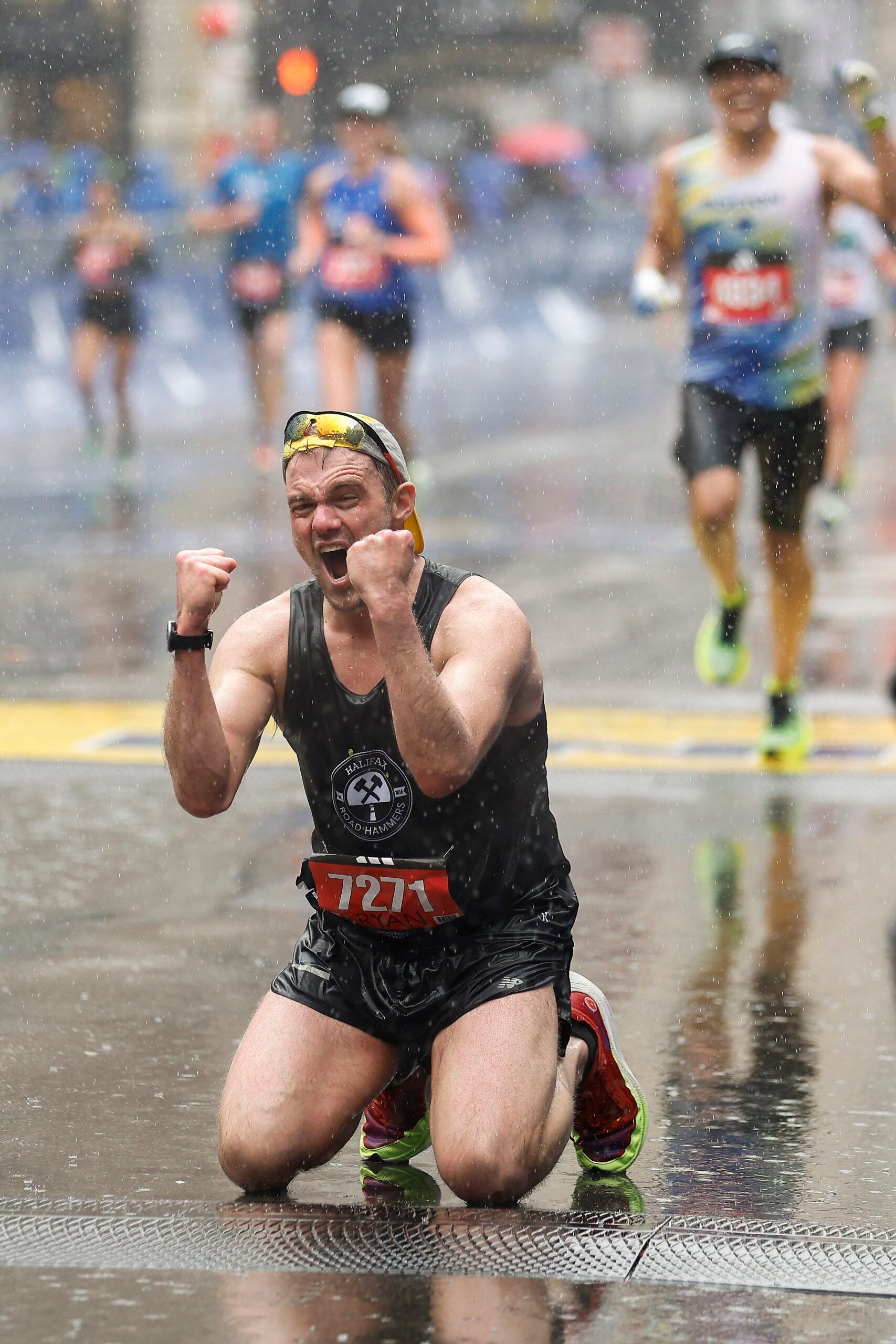 Ryan MacDonald of Canada celebrates on his knees after crossing the finish line of the 127th Boston Marathon Monday, April 17, 2023, in Boston.