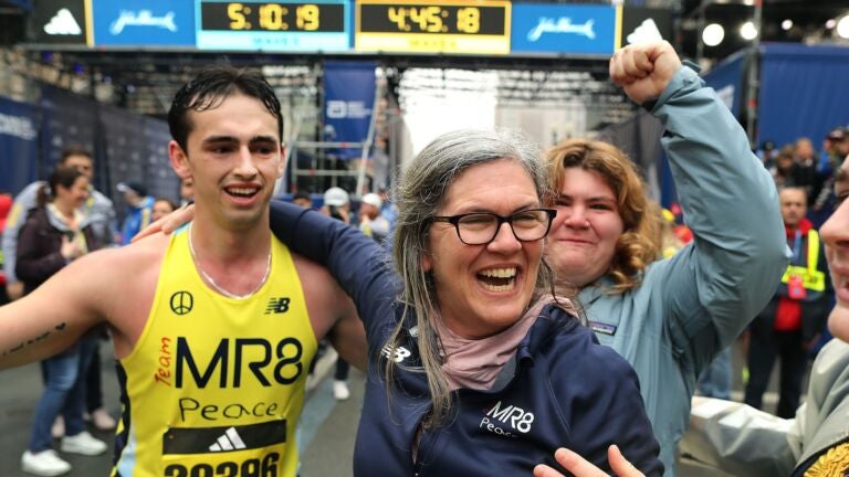 Denise Richard hugs her son Henry(left) as Henry’s sister Jane(right) cries as she hugs an MR8 runner at the finish line.