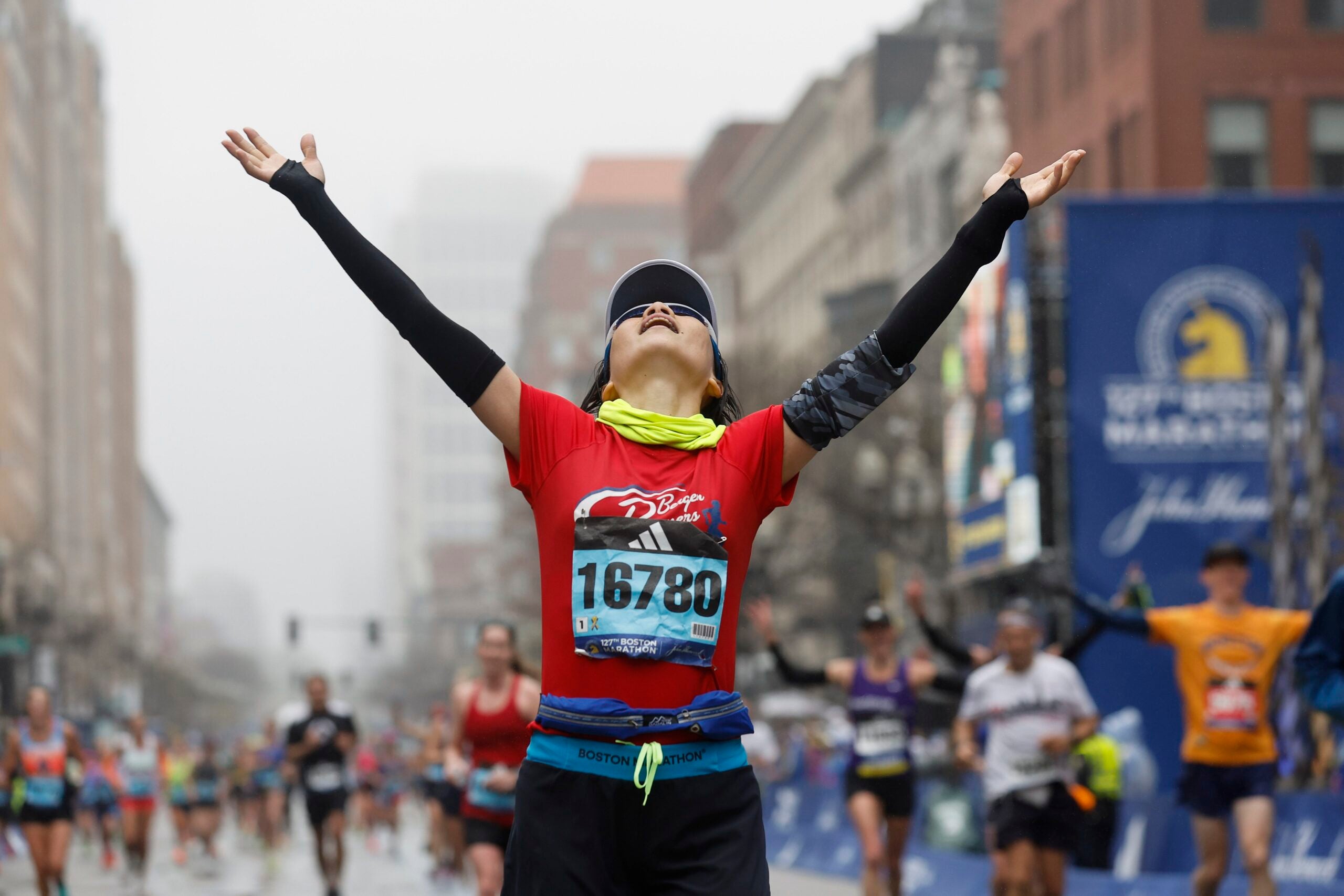 Hui Zhang of China celebrates after crossing the finish line of the 127th Boston Marathon Monday, April 17, 2023, in Boston.