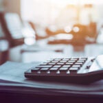 Close up calculator on business working desk, dark background concept.