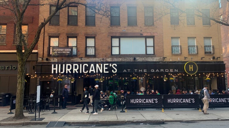 Diners are shown seated outside at tables set up on the sidewalk in front of Hurricane's on Canal Street. There is enough room on the sidewalk for pedestrians to pass by.