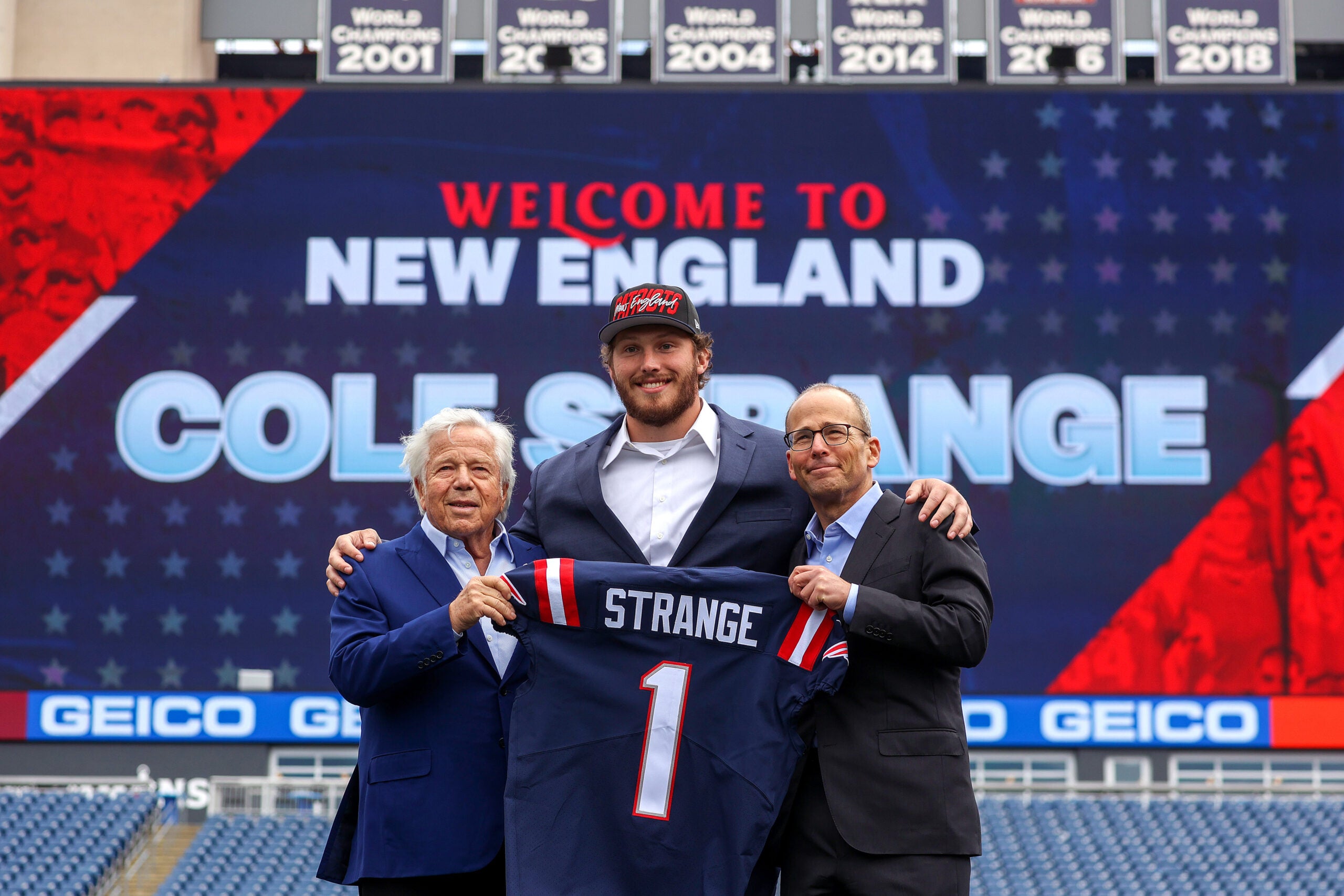 Cole Strange is the most recent first round pick made by Bill Belichick and the Patriots. He stands alongside Robert and Jonathan Kraft at Gillette Stadium.