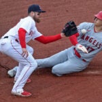 Christian Arroyo fields a throw from catcher to tag out the sliding Shohei Ohtani at second base.