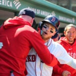 Alex Verdugo gets a hug in the Red Sox dugout.
