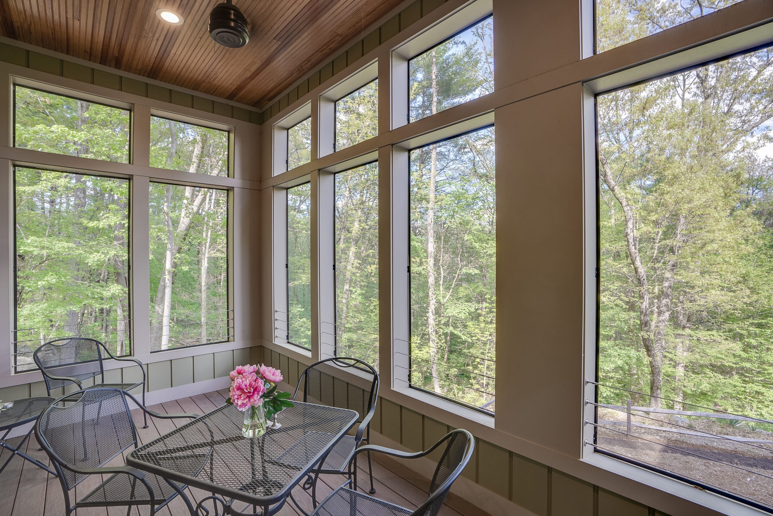 A screen porch comprised of tall windows with a clerestory window set at the top.
