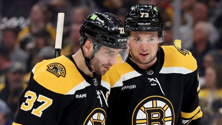 Patrice Bergeron #37 and Charlie McAvoy #73 of the Boston Bruins talk against the Florida Panthers during the second period in Game Five of the First Round of the 2023 Stanley Cup Playoffs at TD Garden on April 26, 2023 in Boston, Massachusetts.