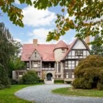 The 9-bed, 8-bath property is set on 1.2 acres behind gates and features a stunning stone facade.