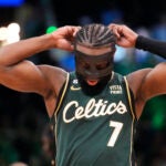 Celtics guard Jaylen Brown putting on his face mask.