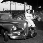Boston Braves outfielder Tommy Holmes waves from the automobile presented to him on "Tommy Holmes Day."