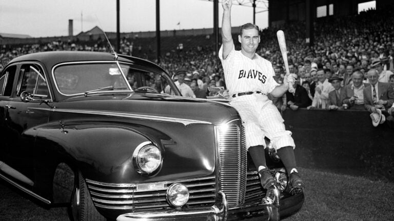 Boston Braves outfielder Tommy Holmes waves from the automobile presented to him on "Tommy Holmes Day."