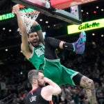 Boston Celtics forward Jayson Tatum, top, dunks as Miami Heat forward Kevin Love defends during the first half in Game 5 of the NBA basketball Eastern Conference finals series Thursday, May 25, 2023, in Boston.