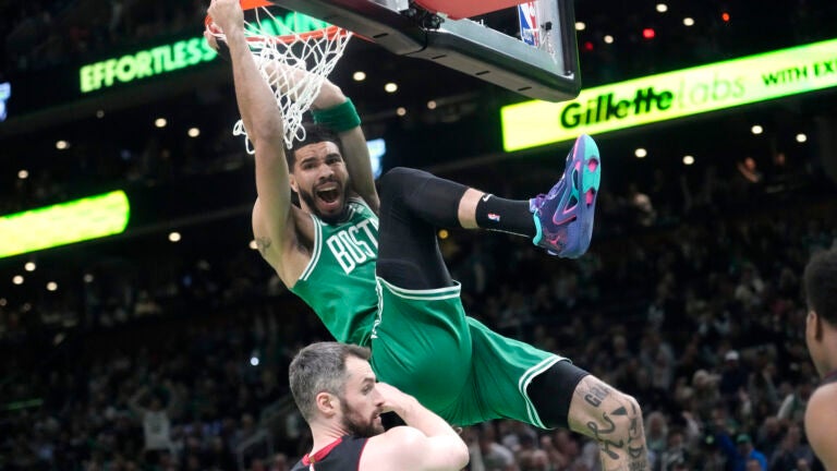 Boston Celtics forward Jayson Tatum, top, dunks as Miami Heat forward Kevin Love defends during the first half in Game 5 of the NBA basketball Eastern Conference finals series Thursday, May 25, 2023, in Boston.